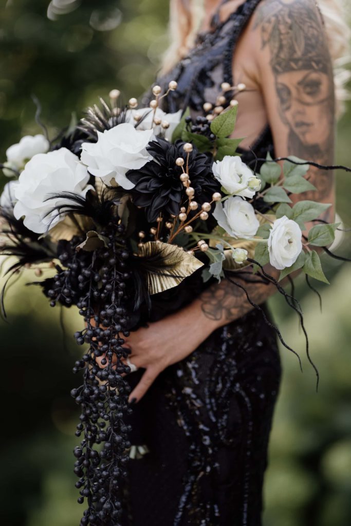 Bride holds bouquet wearing a black wedding dress