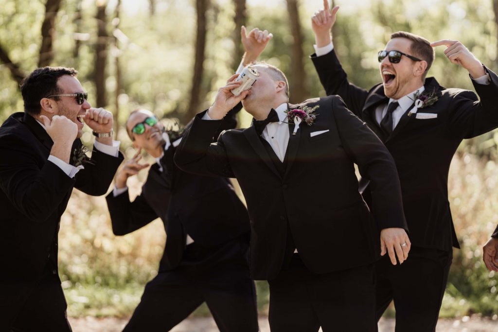Groomsmen shotgun beer at their wedding