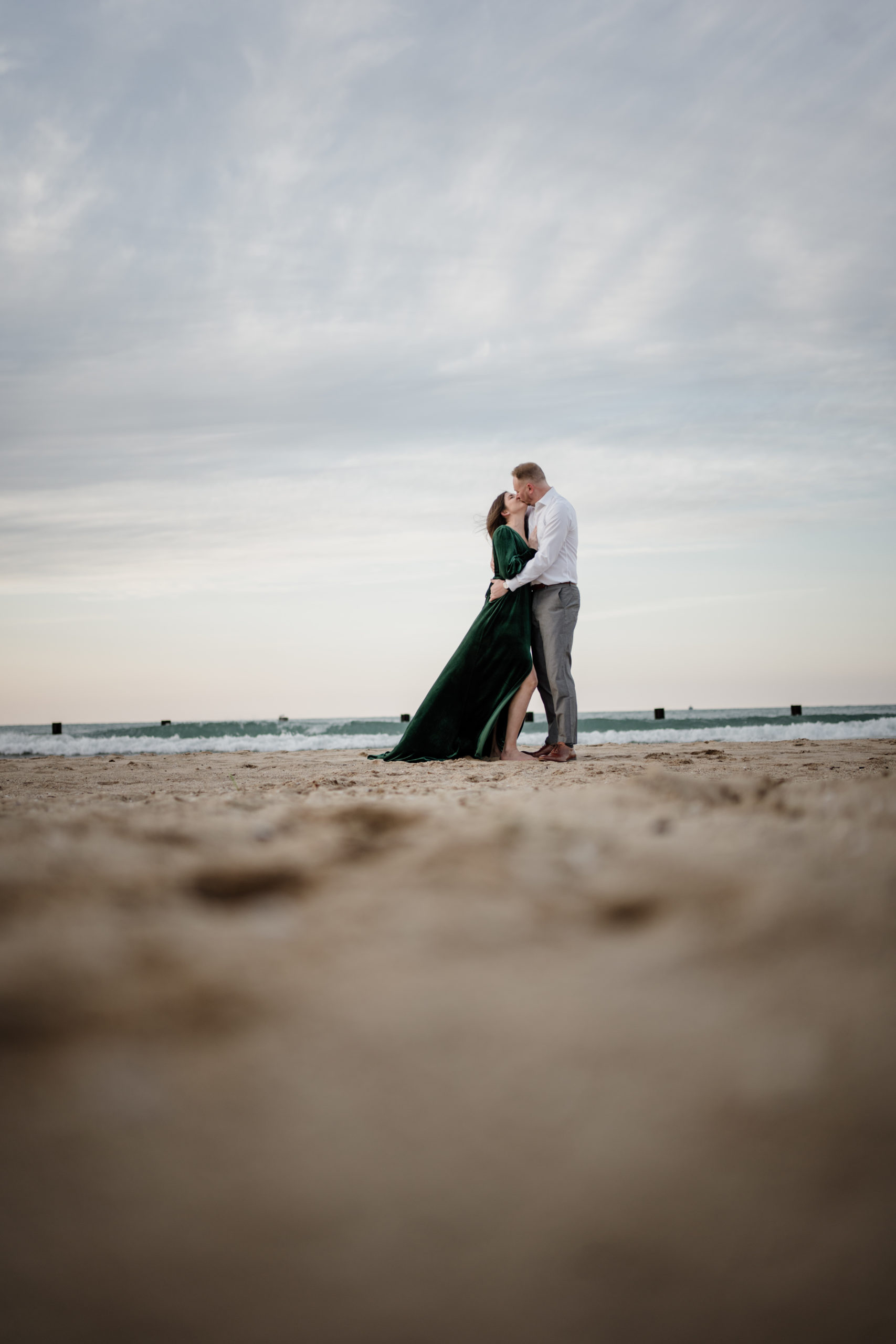 Couple kissing for engagement photos at North Avenue Beach in Chicago