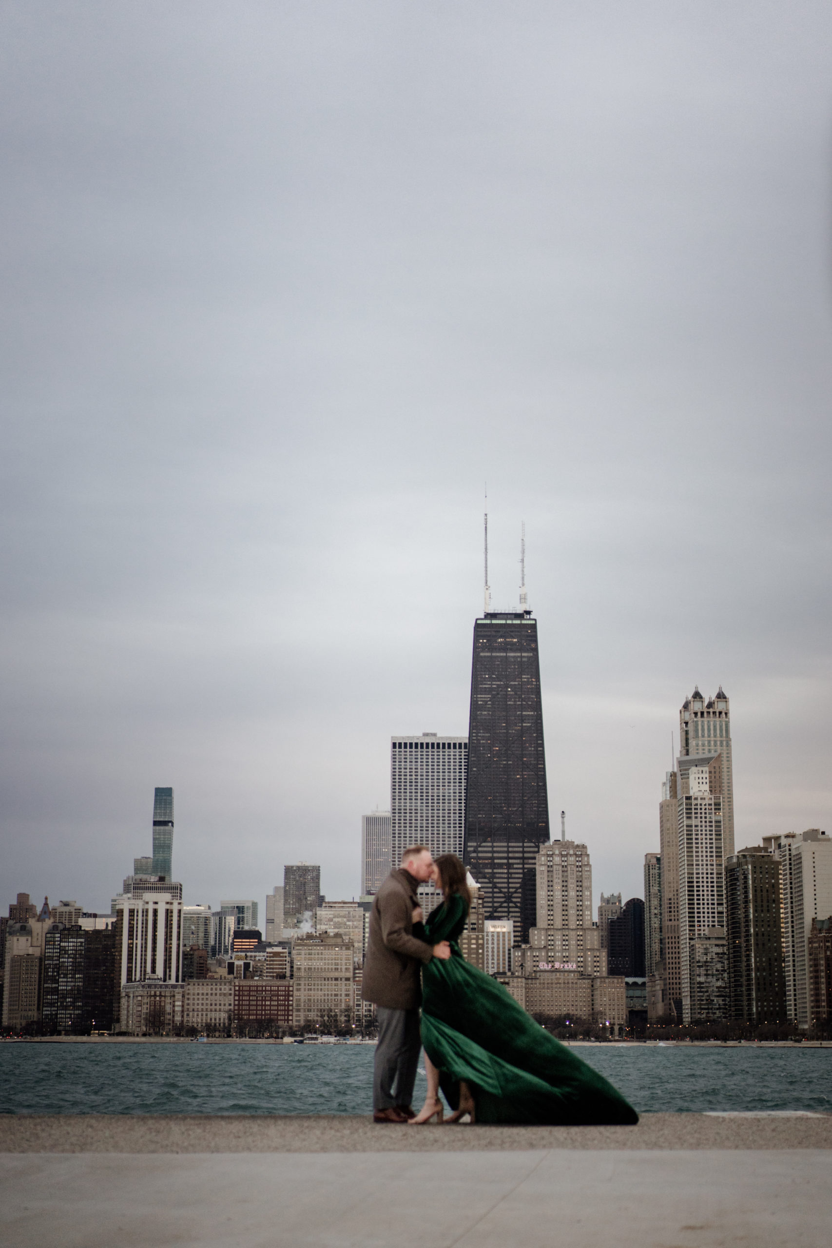 couple kissing with chicago city views for engagement photos