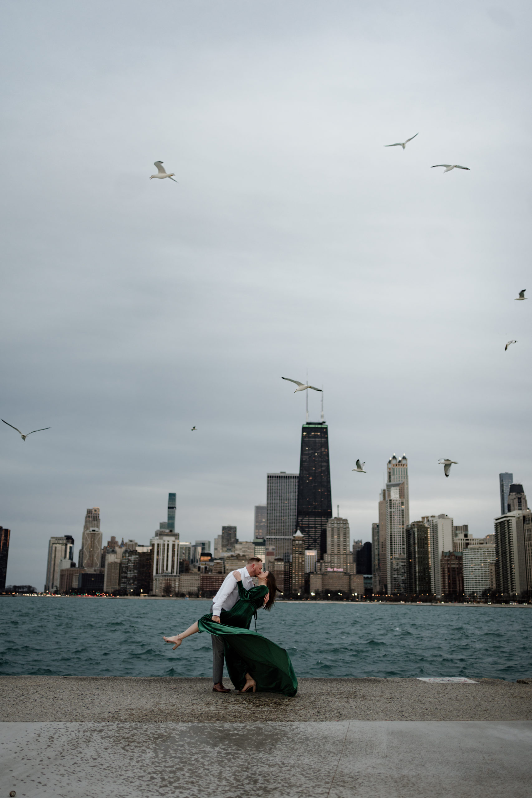 couple kissing with chicago city views for engagement photos